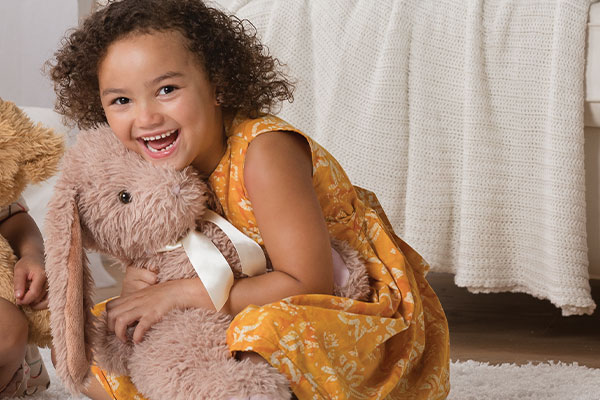 An image of a young child playing with the World's Softest Bunny