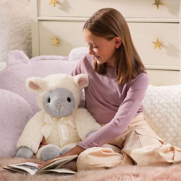 20" World's Softest Lamb - Seated ivory lamb with model in a bedroom scene image number 2