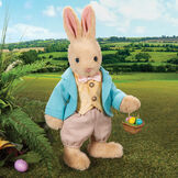 16" Limited Edition Easter Bunny - Jointed Standing Buttercream Rabbit in a turquoise jacket, yellow vest with bow tie, tan knickers holding an Easter basket with eggs. Rabbit is in an outdoor setting.  image number 0