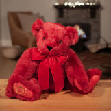 20" Special Edition 40th Anniversary Bear - Seated jointed ruby red bear with red pads and gold Vermont Teddy Bear logo on right foot with red bow in a living room setting image number 0