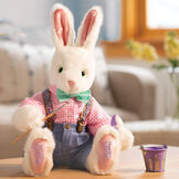 16" Limited Edition Easter Bunny 2022 - Front view of vanilla seated rabbit in pants and shirt with paintbrush and paint in Easter scene image number 3