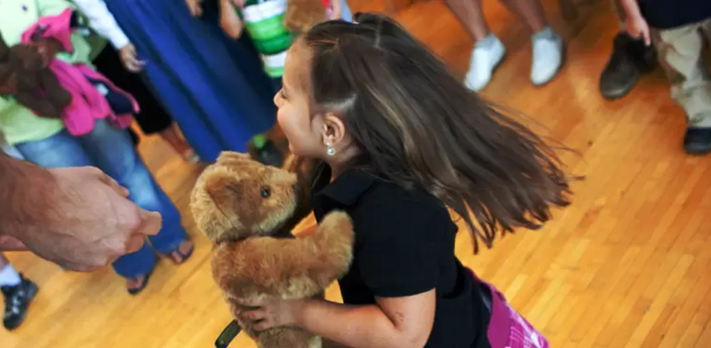 An image of a girl dancing with a teddy bear