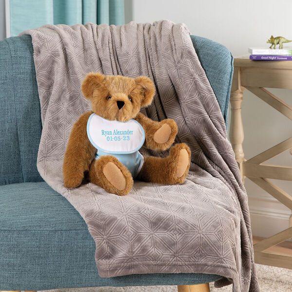 15" Baby Boy Bear - Seated jointed bear dressed in light blue with white dots fabric diaper and bib on a chair in a living room setting image number 1