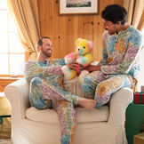 20" True Colors United Rainbow Bear - Front view of rainbow color bear with models in a living room scene image number 1