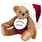 15" Baby's First Christmas Bear - Seated jointed bear dressed in red velvet diaper with santa hat and white and green bib that says ' First Christmas' in red lettering. Bib is personalized with "Jamie" in dark green lettering - Honey brown fur image number 0