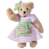 15" Home Is Where Your Mom Is Bear - Front view of standing jointed bear wearing a pink gingham dress, green bow and apron with floral embroidery and says "Home is Where Your Mom Is" - Buttercream brown fur image number 3