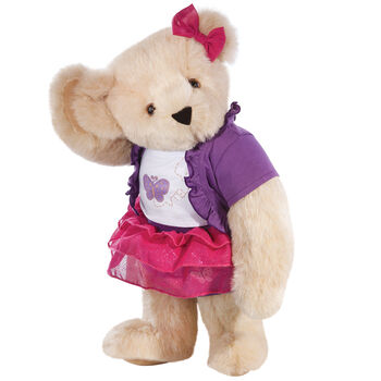 15" Glitter Whimsy Bear - Three quarter view of standing jointed bear dressed in a pink skirt and hair bow, white shirt with butterfly graphic, purple shorts and sweater - Buttercream brown fur